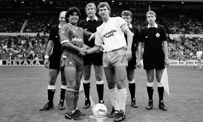 captain of the World team Maradonna, shaking hands with Bryan Robson captain of the Football League representative team